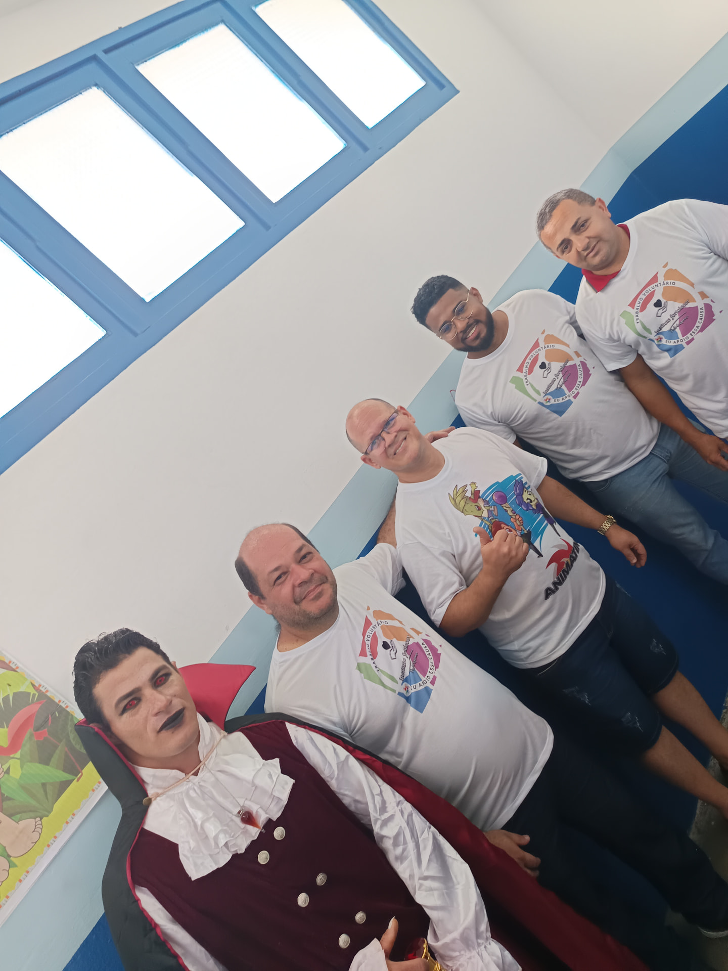 Grupo de voluntários reunidos durante atividade cultural em ambiente escolar