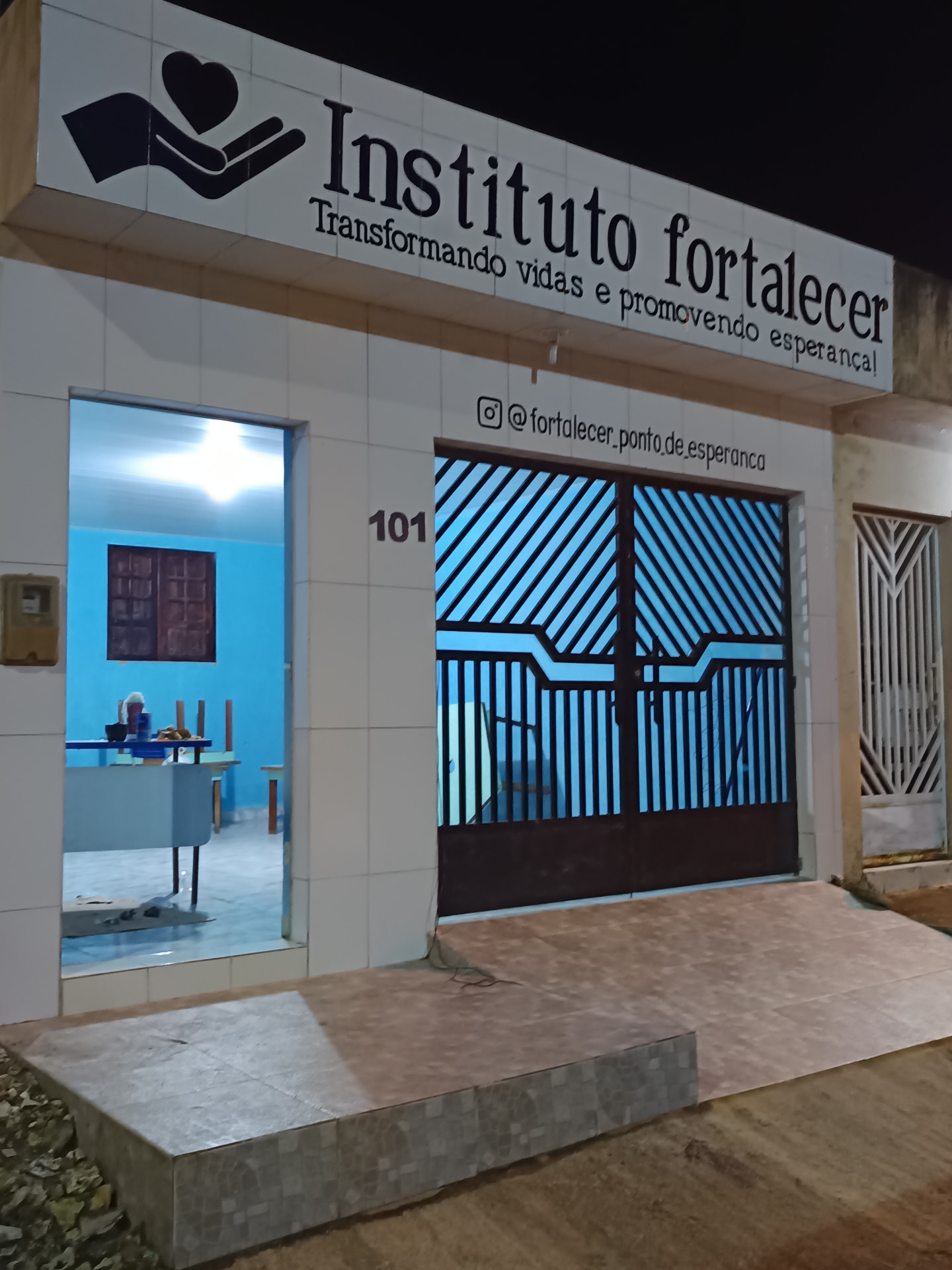 Fachada iluminada da sede do Instituto Fortalecer com letreiro e número 101