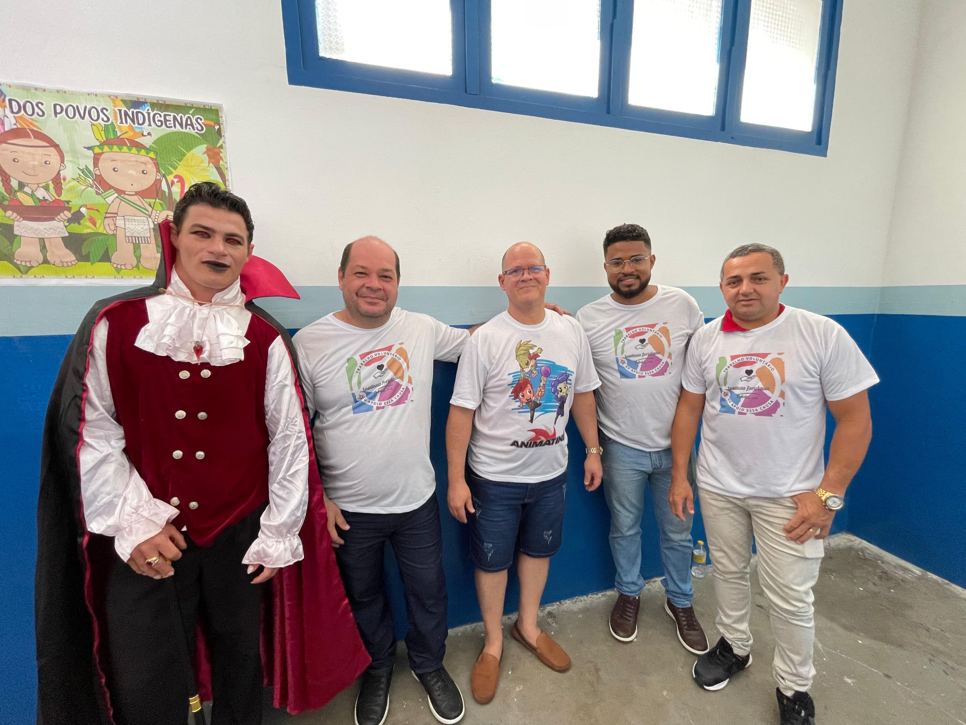 Voluntários do Instituto Fortalecer ao lado de personagem caracterizado em atividade cultural na escola